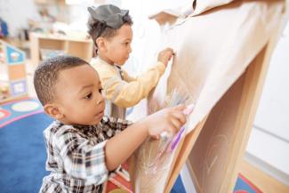 child finger painting in classroom setting